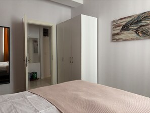 A bedroom with a bed, a wardrobe, and a painting on the wall. - Comfortable 2BR | Walk to Sultanahmet (Istanbul)
