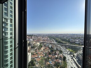 Ein Hochhaus mit Blick auf eine Stadtlandschaft durch ein Fenster.
