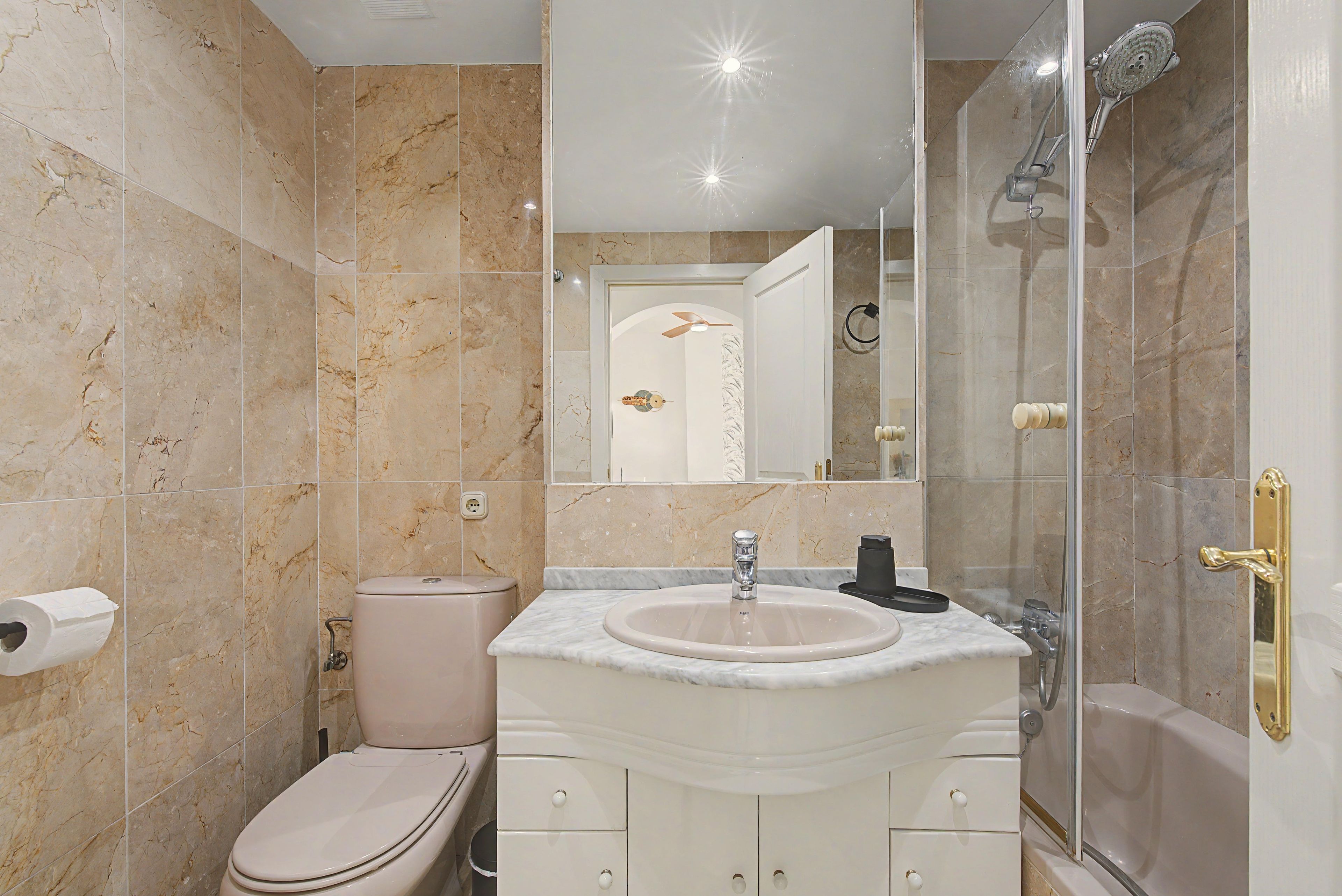 Une salle de bain avec des toilettes, un lavabo et une douche.