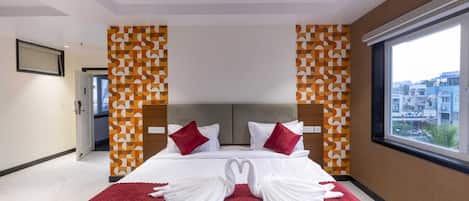 A hotel room with a bed, a ceiling fan, and a window with a city view.