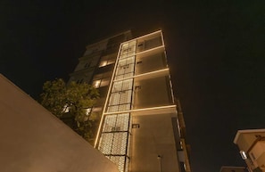 A multi-story building with a patterned facade and illuminated edges.