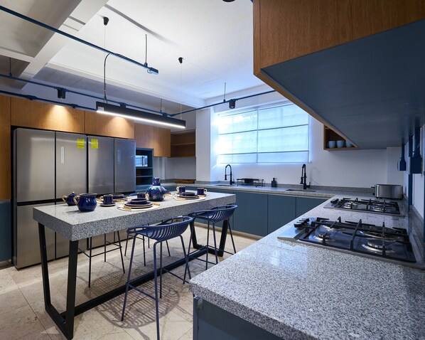 A modern kitchen with granite countertops, stainless steel appliances, and bar stools. - Confortable 2 Bedroom accomodation C3 (Ciudad de México)