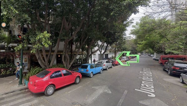 Una strada con auto parcheggiate e alberi.