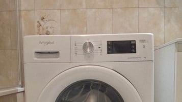 Een Whirlpool wasmachine met een digitaal display, een bedieningspaneel en een sticker met 10 jaar garantie.