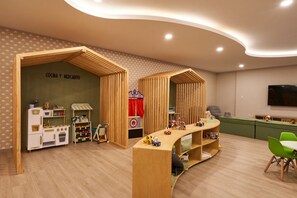 A children's playroom with wooden play structures, a kitchen play area, and a green seating area. - Elegant Loft with pool (Ciudad de México)