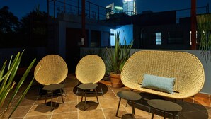 An outdoor seating area with wicker furniture and potted plants. - Nice room with private bathroom La Condesa C16 (Ciudad de México)