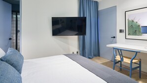 A modern bedroom with a bed, a desk, a television, and a door. - Nice room with private bathroom La Condesa C16 (Ciudad de México)