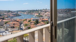 A cityscape with a river, buildings, and a bridge. - GuestReady - Chic Riverside Apartment Retreat (Vila Nova de Gaia)