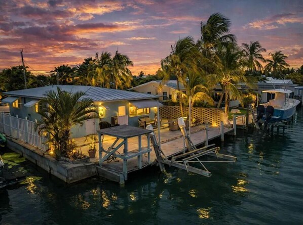 A waterfront property with multiple buildings, a dock, and palm trees. - *NEW* Reel Escape~50'Dock!!~Pet Friendly!~Grill! (Marathon)