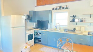 Une cuisine équipée d’un réfrigérateur, d’une cuisinière, d’un four à micro-ondes et d’une fenêtre située au-dessus de l’évier.