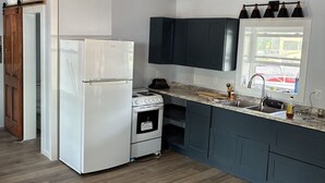 Une cuisine équipée d’un réfrigérateur, d’une cuisinière et de placards.