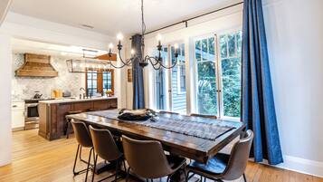 Un coin repas avec une table en bois, quatre chaises et un lustre.