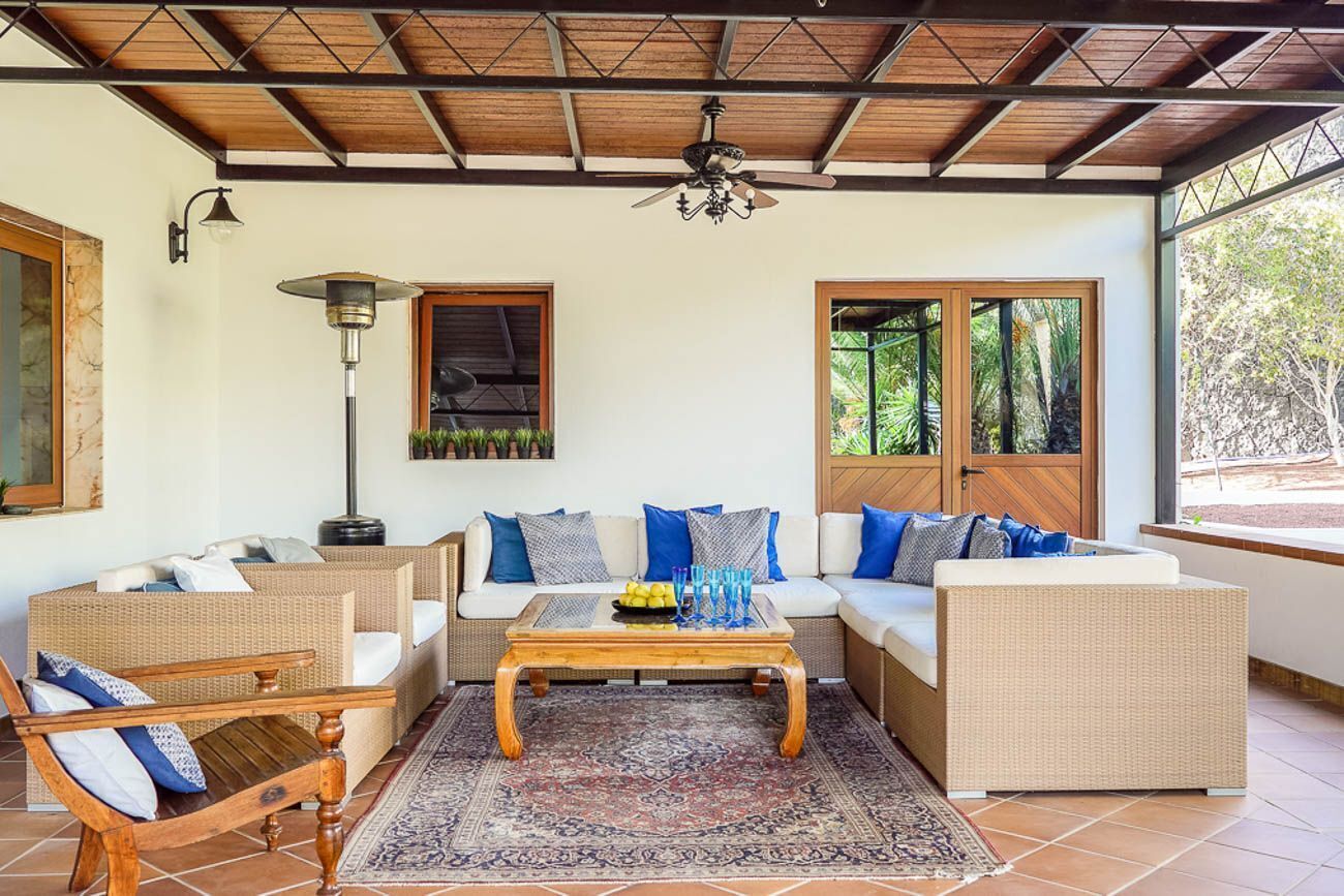 A furnished living area with a ceiling fan, a coffee table, and two sofas with cushions.