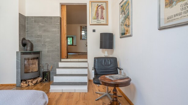 A modern living room with a fireplace, a staircase, and a dining area. - Holiday Apartment in Kipfenberg – 1 Bedroom / Sleeping Gallery / 2 Bathrooms (Kipfenberg)