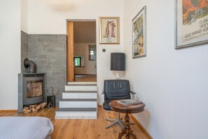 A modern living room with a fireplace, a staircase, and a dining area.