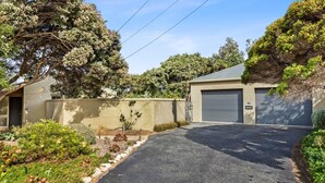 En uppfart som leder till ett bostadshus och vidare till ett garage med garagedörr nummer 25.