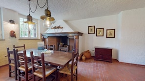 A dining area with a wooden table and chairs, a fireplace, and a rustic decor. - Villa Sunset Lakeview—Private Pool—by Booking Gard (Soiano del Lago)
