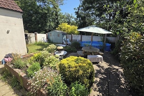 Ein Garten mit Pool, Gartenmöbeln und einem Schuppen.