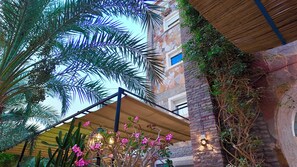 A building with a stone facade, a wooden ceiling, and a balcony with a yellow awning. - Hôtel Résidence le Berger (Nouakchott)