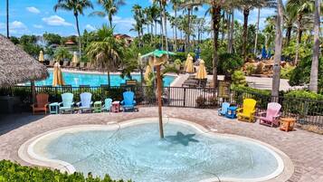 A pool area with a hot tub, lounge chairs, and a sign indicating a restroom.