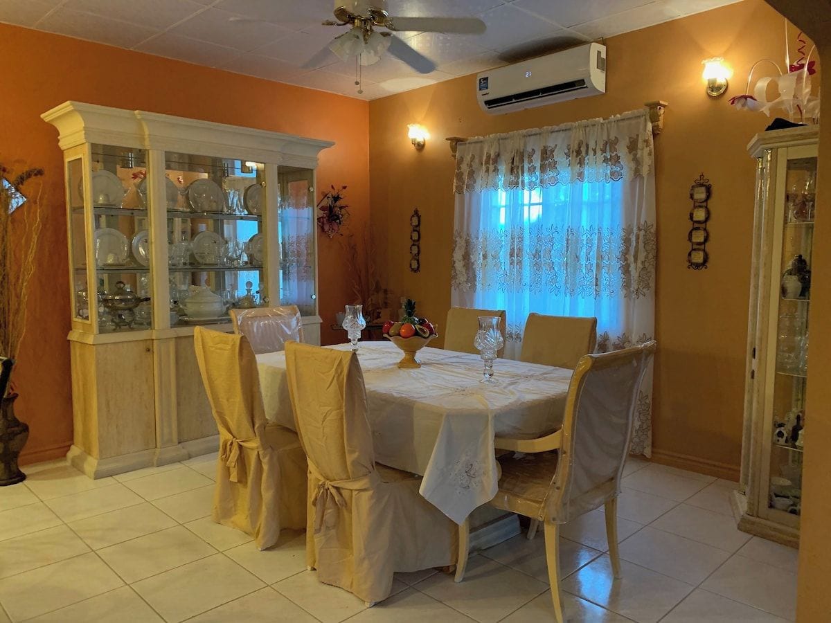 Un coin repas avec une table ronde, des chaises et un ventilateur de plafond.