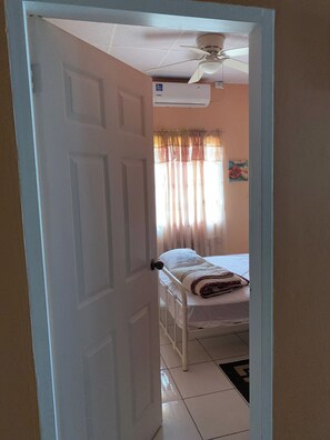 A room with a bed, a ceiling fan, and an air conditioning unit. - Alluring Ambrosia (Arouca)