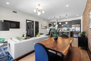 A modern living space with a dining area, kitchen, and seating area. - Eleven48 by NOLA Luxury Collection (New Orleans)