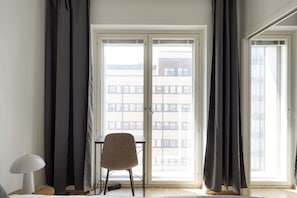 A room with a large window, a chair, and a table.