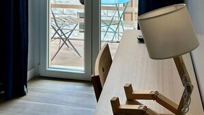 Quarto com porta de correr de vidro que dá para uma área externa com mesa e cadeiras.