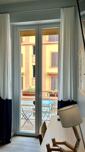 A room with a sliding glass door leading to an outdoor seating area with a table and chairs. - St.Peter's Basilica Apartment (Roma)