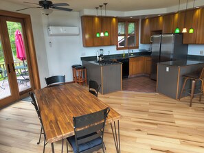 Une cuisine moderne avec des meubles en bois, un îlot central et un coin repas comprenant une table et des chaises en bois.