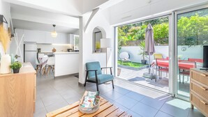 Een modern interieur met een keuken, een eethoek en een terras met uitzicht op groen.