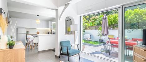 Un interior moderno con cocina, comedor y un patio con vistas a zonas verdes.