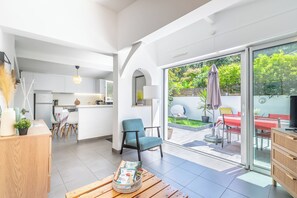 Ein modernes Interieur mit einer Küche, einem Essbereich und einer Terrasse mit Blick auf Grünflächen.