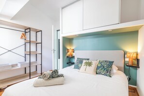 Ein Schlafzimmer mit einem Bett, zwei Nachttischlampen, einem Kopfteil, einem Wandregal und einer Holzleiter.