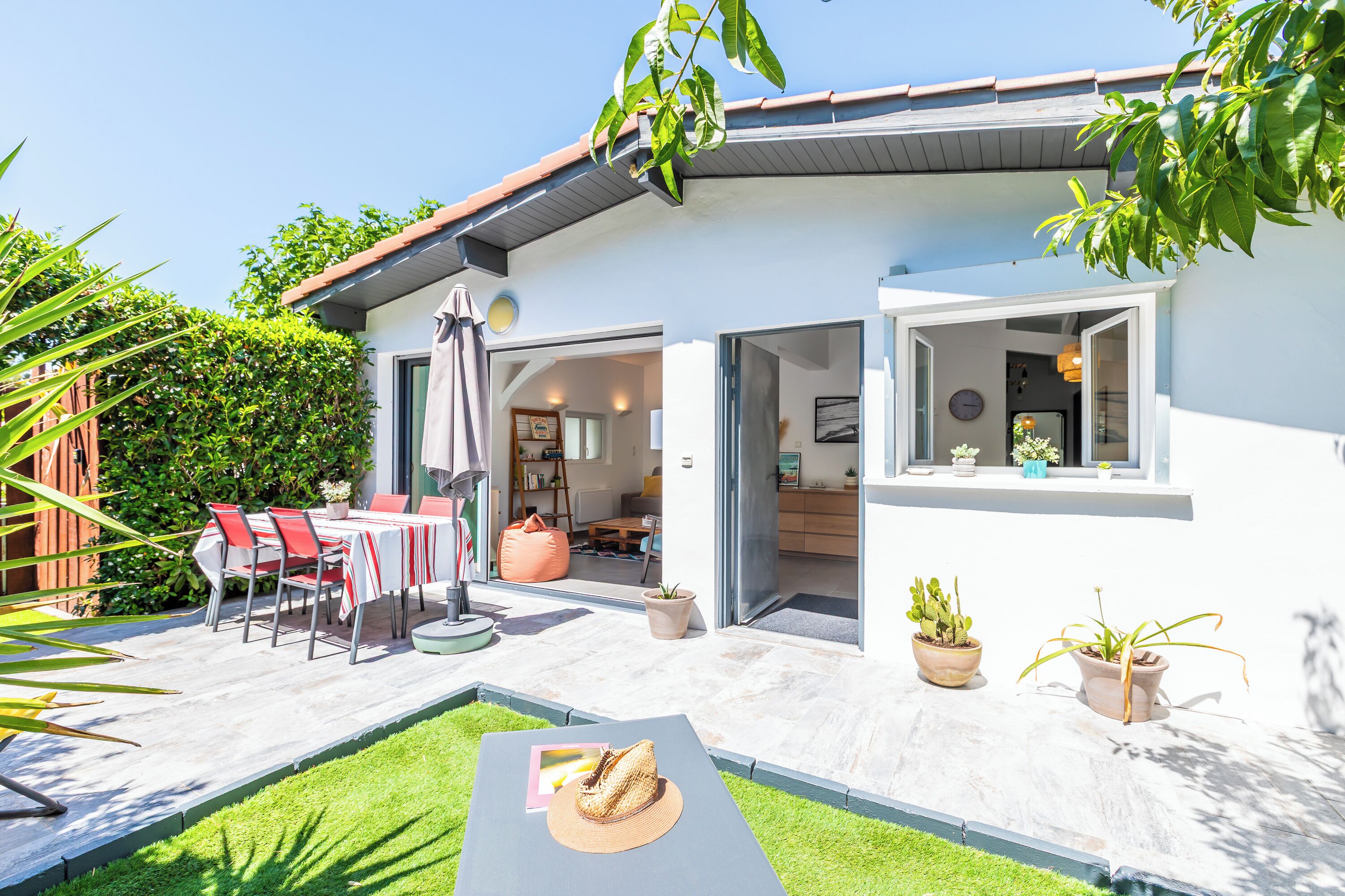 Ein modernes Haus mit Terrasse, Essbereich und Wohnzimmer.