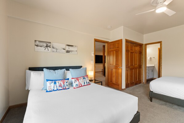 A hotel room with a large bed, two pillows, a ceiling fan, and a door leading to a bathroom. - Spacious Mountain Home, Private Deck, Central Location in Dillon (Dillon)