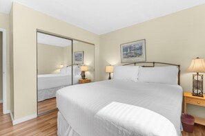 A hotel room with a large bed, two bedside tables with lamps, a mirror, and a painting on the wall. - Ski-In Comfort: 2BR Breckenridge Village Retreat w/ Pool & Views (Breckenridge)