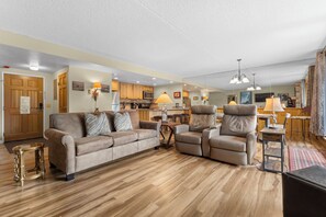 Ein geräumiges Wohnzimmer mit einer Couch, einem Liegesessel und einem Essbereich mit Tisch und Stühlen.