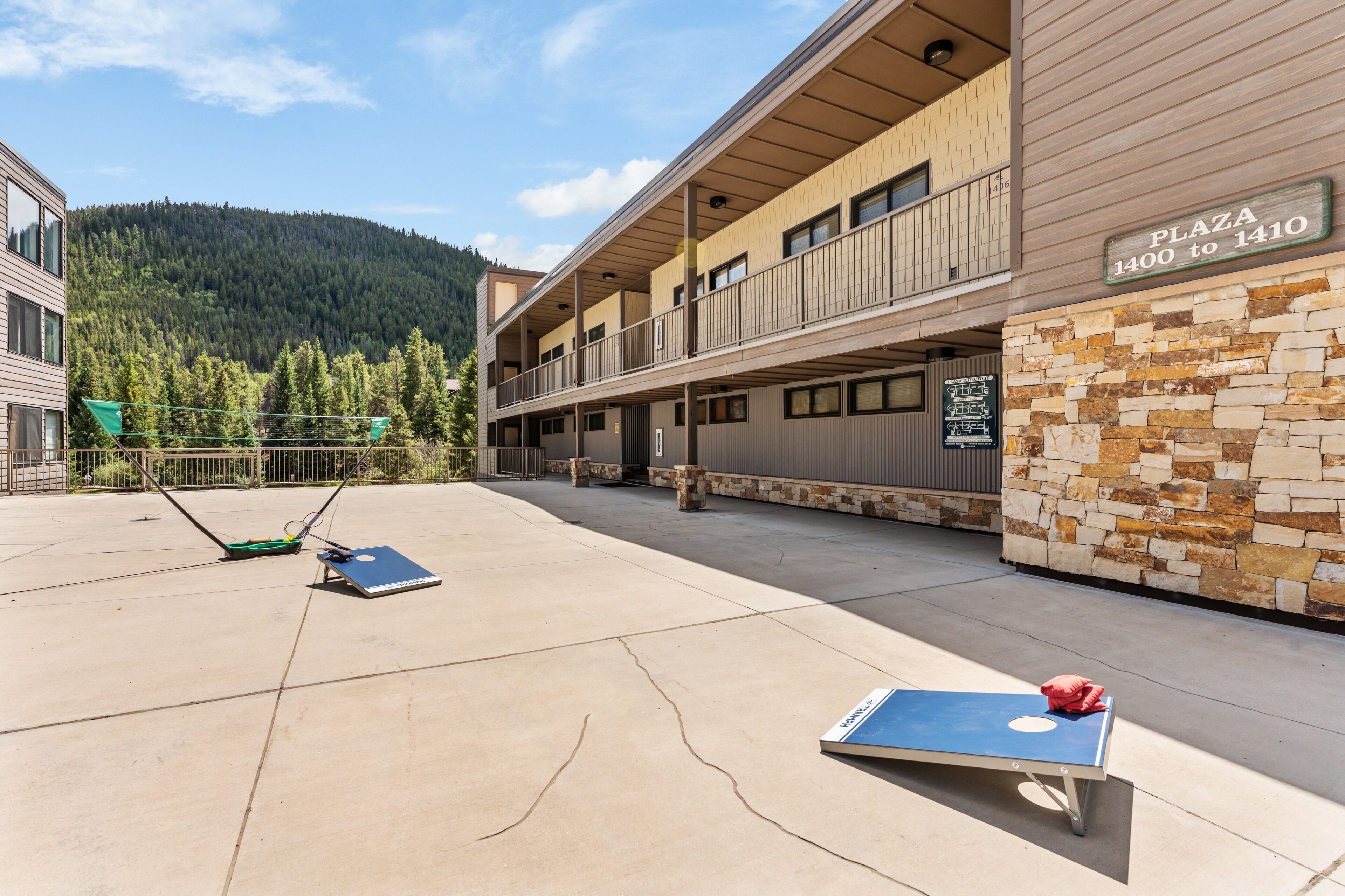 Un espacio al aire libre con mesa de ping pong, raqueta de tenis y red.