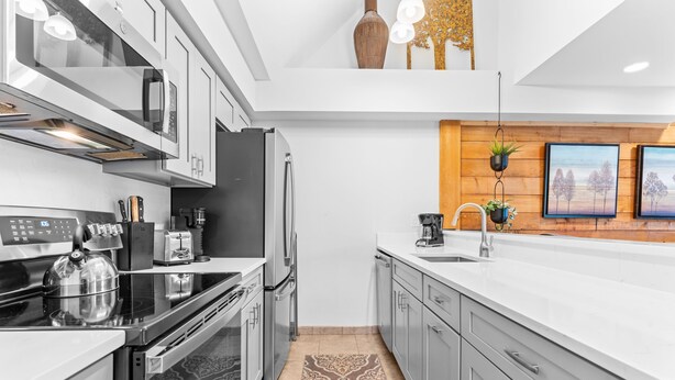 A modern kitchen with stainless steel appliances, a built-in oven, and a large island with a sink. - Sleeps 7: Resort-Style Keystone Condo w/ Private Balcony (Keystone)