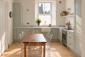 Una cocina moderna con una mesa y sillas de madera, una ventana con vistas a la ciudad y un horno empotrado.