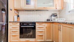 Eine Küche mit Holzausstattung, Backofen, Kaffeemaschine und einem Schild mit Familienregeln.