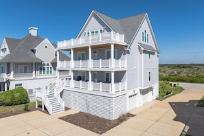 Ein zweistöckiges Haus mit Balkon, Treppe und Garage.
