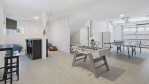Un interior moderno con mesa de futbolín, mesa de ping pong y zona de bar.
