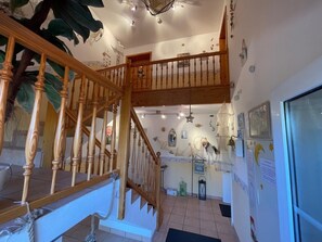 A multi-level interior with a wooden staircase, a kitchen area, and a dining space. - 30 Vacation Rental "Anders Fewo 4" (Burg auf Fehmarn)