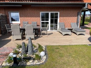 A patio with outdoor furniture, a brick building, and a landscaped garden area. - 30 Vacation Rental "Anders Fewo 4" (Burg auf Fehmarn)