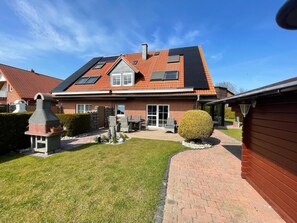 A residential property with a sloped roof, a brick exterior, a paved driveway, and a well-maintained lawn. - 30 Vacation Rental "Anders Fewo 4" (Burg auf Fehmarn)