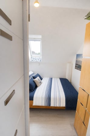 A bedroom with a bed, a window, and a view of the outside. - 60 "Inselglück" Vacation Rental (Fehmarn Neue Tiefe)