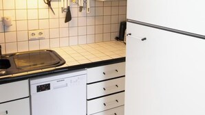 Eine Küche mit weißen Schränken, einem Geschirrspüler und einer Arbeitsfläche mit Spüle.